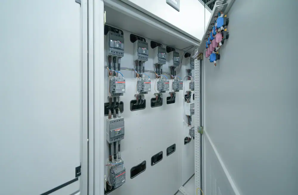 A close-up view of an electrical control panel with several circuit breakers and wiring inside an industrial cabinet, organized and labeled by a professional electrician Cook and Will County for quality IL electrical services.
