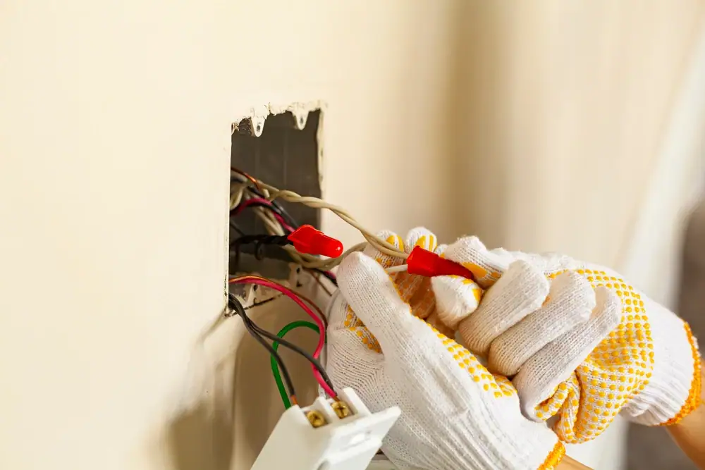 An electrician installing electrical wiring in a residential home in Cook and Will County, IL. The technician is carefully connecting wires, ensuring safety and precision during the installation process.