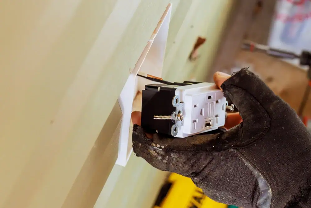 Electric outlet installation in a home in Cook & Will County, IL, with a technician expertly wiring and securing the electrical outlet for safe and reliable use.