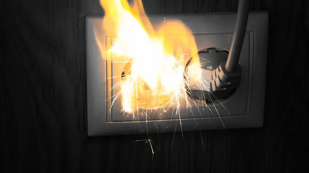 Close-up of an electrical outlet emitting sparks, highlighting a potential fire risk in Chicago, IL homes. Jimco Electric offers expert repair and safety solutions