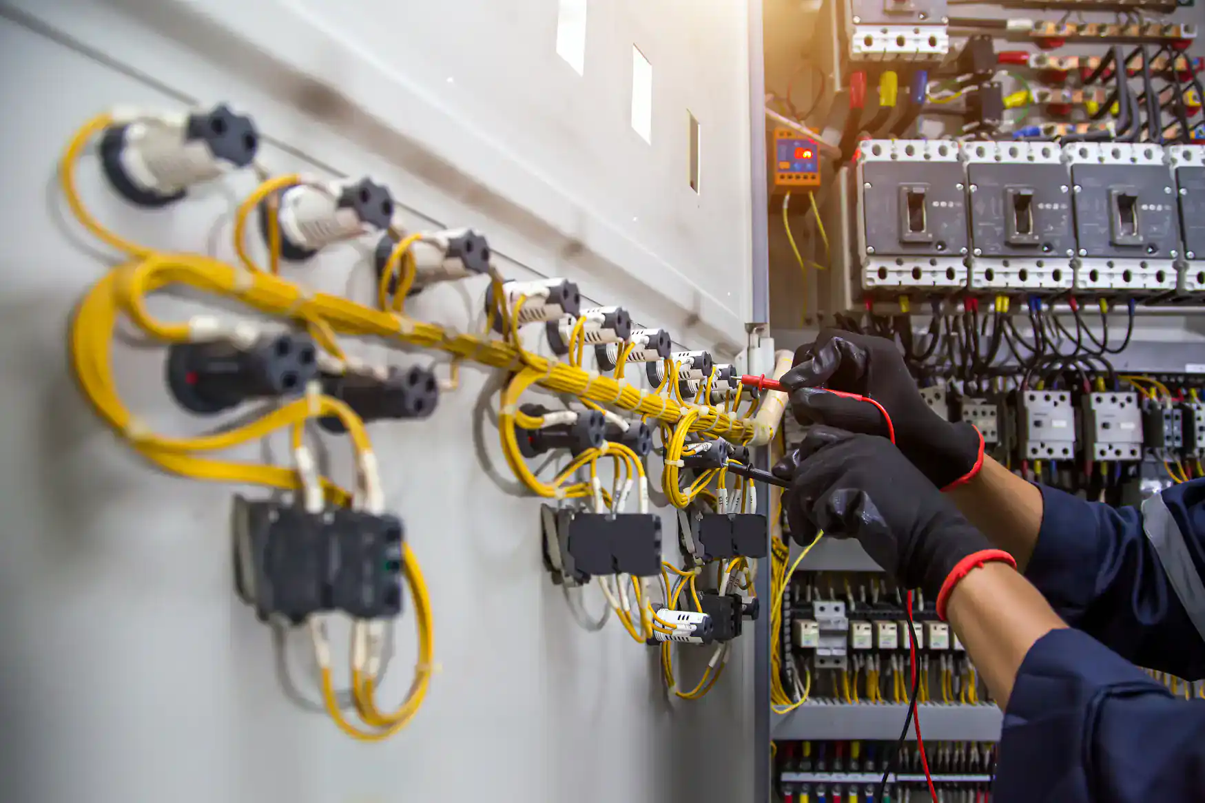 Electrician from Jimco Electric installing and organizing circuit wires in a panel in Chicago, IL for reliable home electricity