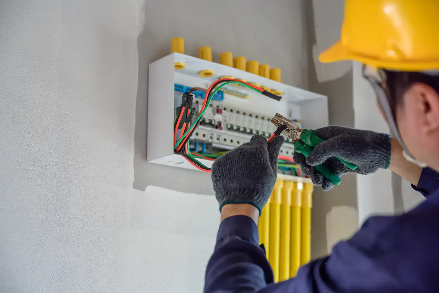 Electrician from Jimco Electric carefully works on a fuse box in Chicago, IL, ensuring safe electrical connections and maintenance in a residential or commercial setting